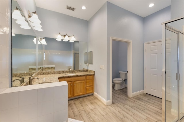 full bathroom with a shower stall, wood finished floors, toilet, and baseboards