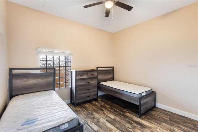 bedroom with baseboards, dark wood-type flooring, and ceiling fan
