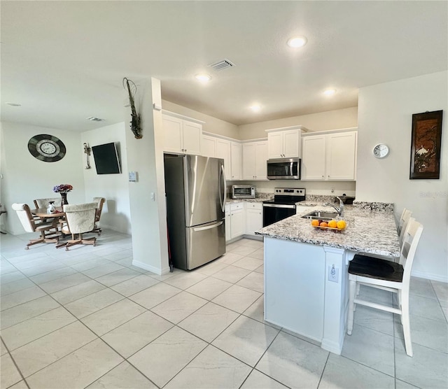 7871 Penrose Pl, Wildwood, FL 34785 - kitchen with appliances with stainless steel finishes, a sink, a peninsula, white cabinetry, and visible vents