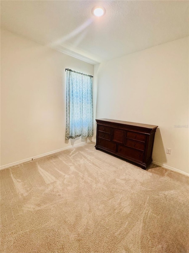 7871 Penrose Pl, Wildwood, FL 34785 - unfurnished bedroom with baseboards and light colored carpet
