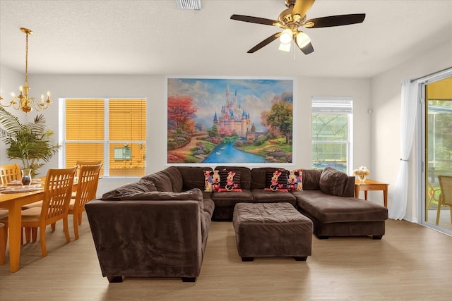 1031 Marcello Blvd, Kissimmee, FL 34746 - living area featuring light wood-style floors, ceiling fan with notable chandelier, and visible vents