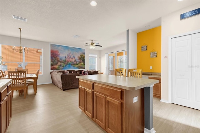 1031 Marcello Blvd, Kissimmee, FL 34746 - kitchen with light wood-style floors, light countertops, a center island, and visible vents
