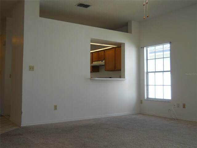 unfurnished room featuring visible vents and light carpet