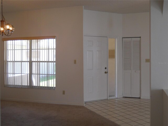 interior space featuring baseboards, an inviting chandelier, and light tile patterned floors