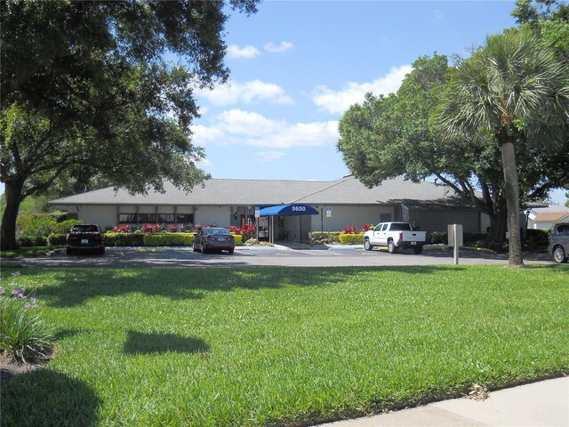 view of front of home with uncovered parking and a front lawn