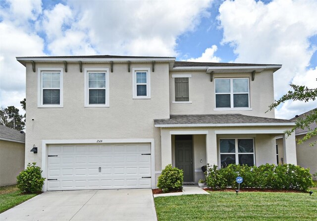 traditional-style home featuring a garage, a front lawn, stucco siding, and concrete driveway