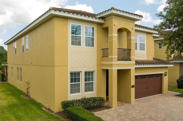 7519 Marker Ave, Kissimmee, FL 34747 - view of front of property featuring an attached garage, stucco siding, a tile roof, decorative driveway, and a balcony