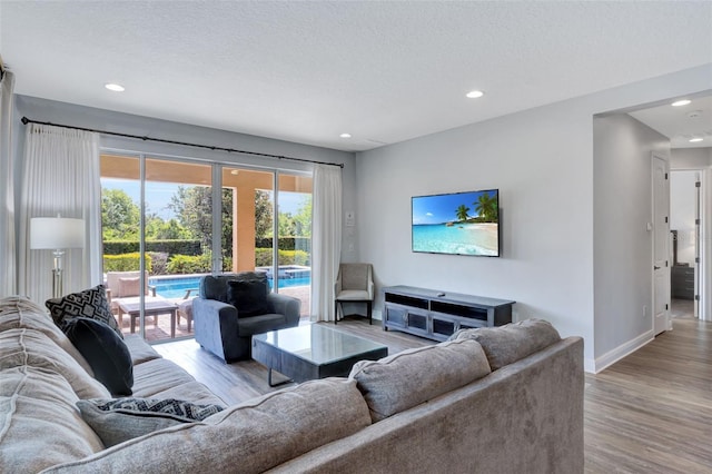 7519 Marker Ave, Kissimmee, FL 34747 - living area featuring a textured ceiling, wood finished floors, baseboards, and recessed lighting