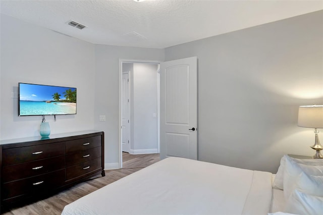 7519 Marker Ave, Kissimmee, FL 34747 - bedroom featuring baseboards, light wood-style floors, visible vents, and a textured ceiling