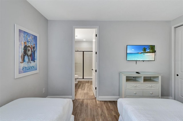7519 Marker Ave, Kissimmee, FL 34747 - bedroom featuring ensuite bathroom, baseboards, and wood finished floors