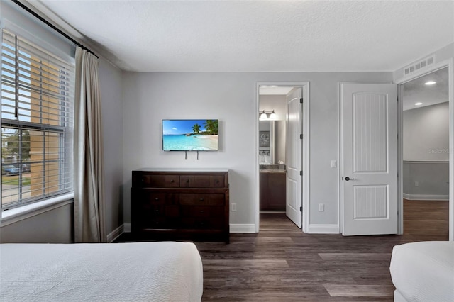 7519 Marker Ave, Kissimmee, FL 34747 - bedroom with connected bathroom, baseboards, visible vents, and wood finished floors