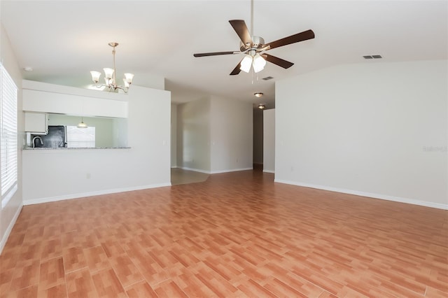 1653 Turtle Rock Dr, Lakeland, FL 33803 - unfurnished living room featuring visible vents, light wood-style floors, ceiling fan with notable chandelier, baseboards, and vaulted ceiling