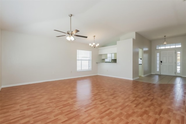 1653 Turtle Rock Dr, Lakeland, FL 33803 - unfurnished living room with ceiling fan with notable chandelier, light wood finished floors, and lofted ceiling