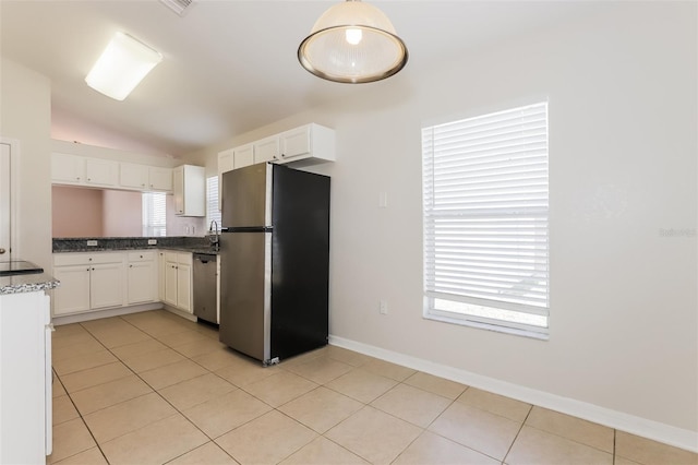 1653 Turtle Rock Dr, Lakeland, FL 33803 - kitchen with white cabinets, appliances with stainless steel finishes, light tile patterned floors, and vaulted ceiling