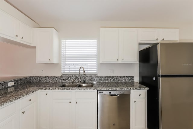 1653 Turtle Rock Dr, Lakeland, FL 33803 - kitchen with a sink, dark stone counters, white cabinets, and stainless steel appliances