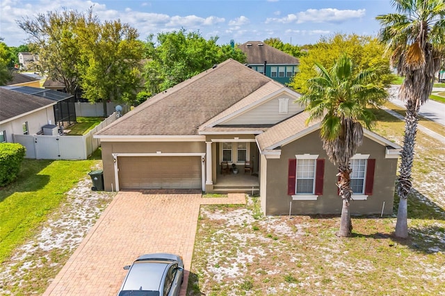 view of front of home featuring a shingled roof, a gate, an attached garage, and stucco siding