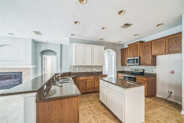 807 Ayden Oak Ln, Ocoee, FL 34761 - kitchen featuring backsplash, stainless steel appliances, arched walkways, and a sink