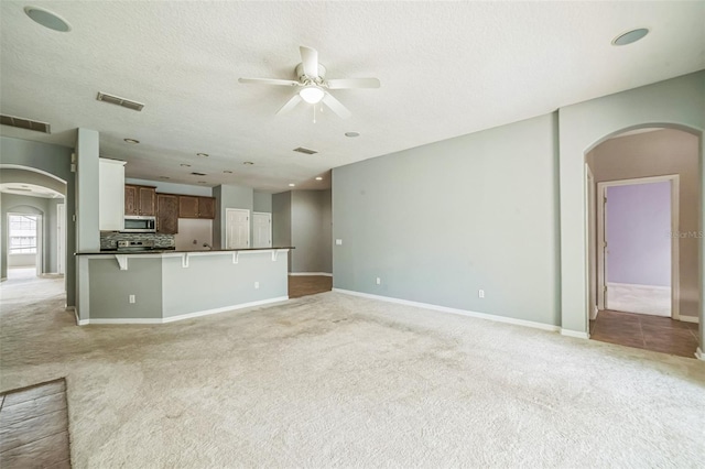 807 Ayden Oak Ln, Ocoee, FL 34761 - unfurnished living room with arched walkways, visible vents, and light colored carpet