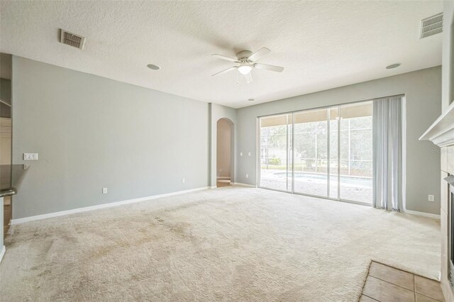 807 Ayden Oak Ln, Ocoee, FL 34761 - unfurnished living room featuring a fireplace, baseboards, ceiling fan, arched walkways, and carpet flooring