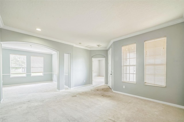 807 Ayden Oak Ln, Ocoee, FL 34761 - spare room with crown molding, arched walkways, baseboards, and light carpet