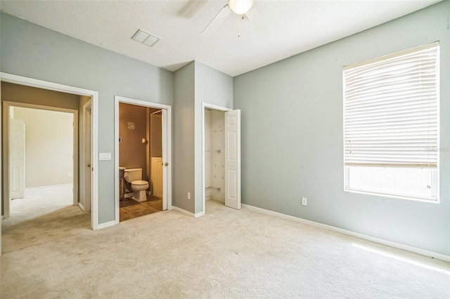 807 Ayden Oak Ln, Ocoee, FL 34761 - unfurnished bedroom with a ceiling fan, visible vents, baseboards, ensuite bathroom, and light carpet