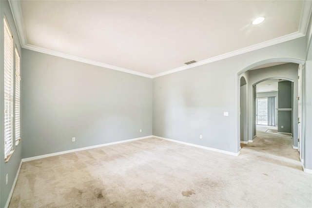 807 Ayden Oak Ln, Ocoee, FL 34761 - spare room with crown molding, arched walkways, visible vents, and light carpet