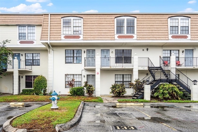 6095 Village Cir Unit 6095, Orlando, FL 32822 - view of front of property featuring uncovered parking, stairs, mansard roof, and stucco siding