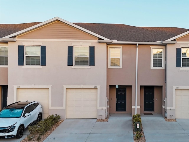 1089 Blue Jay Dr, Davenport, FL 33837 - view of property featuring a shingled roof, stucco siding, driveway, and a garage