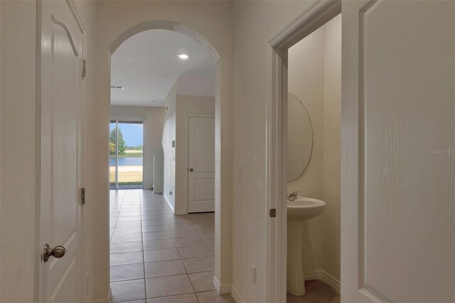 1089 Blue Jay Dr, Davenport, FL 33837 - hall featuring a water view, arched walkways, baseboards, and light tile patterned floors