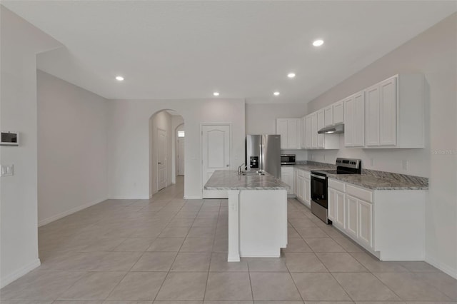 1089 Blue Jay Dr, Davenport, FL 33837 - kitchen with recessed lighting, light stone counters, white cabinetry, arched walkways, and appliances with stainless steel finishes