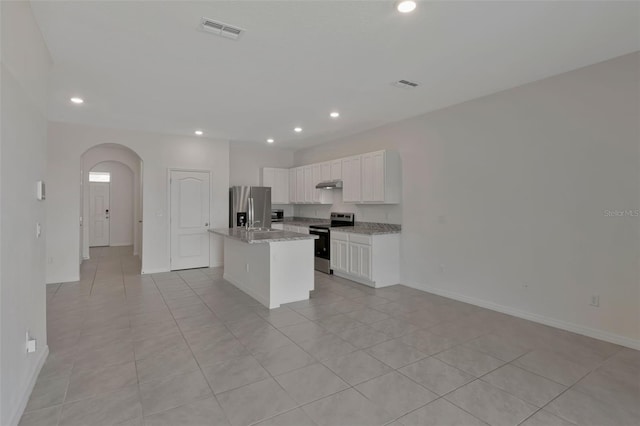 1089 Blue Jay Dr, Davenport, FL 33837 - kitchen with a kitchen island with sink, visible vents, arched walkways, appliances with stainless steel finishes, and recessed lighting
