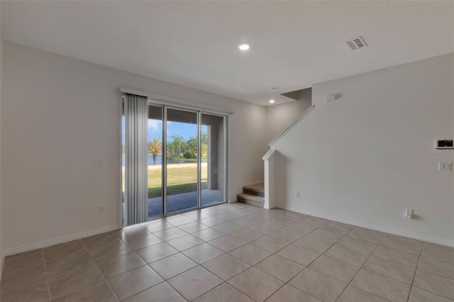 1089 Blue Jay Dr, Davenport, FL 33837 - empty room featuring visible vents, light tile patterned flooring, stairway, and recessed lighting