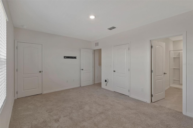 1089 Blue Jay Dr, Davenport, FL 33837 - unfurnished bedroom with baseboards, ensuite bathroom, visible vents, and light colored carpet