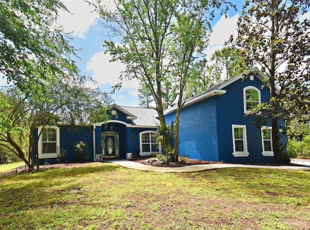 view of front of property featuring stucco siding and a front lawn