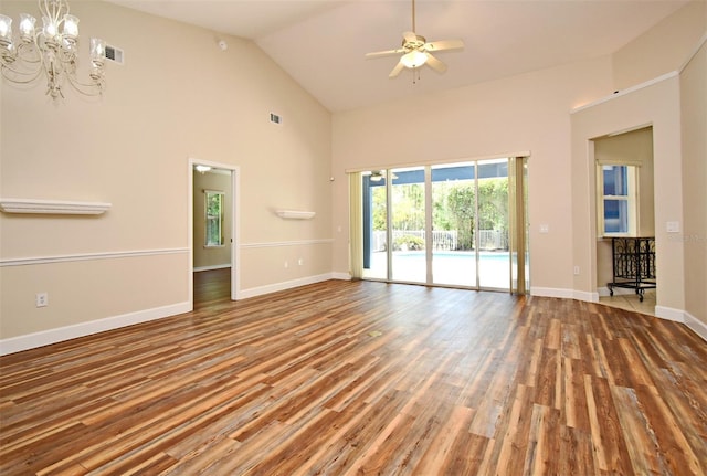 unfurnished living room featuring visible vents, wood finished floors, high vaulted ceiling, baseboards, and ceiling fan with notable chandelier
