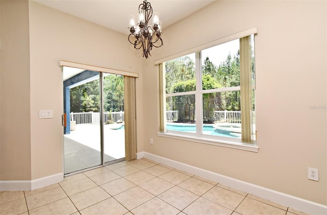 unfurnished dining area featuring baseboards, light tile patterned floors, and a notable chandelier