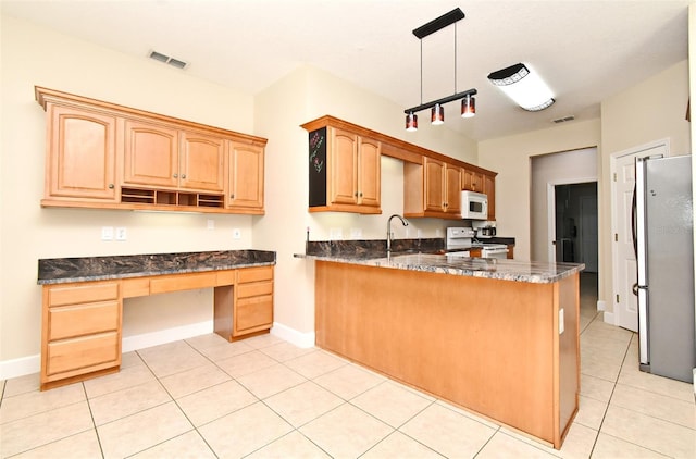 kitchen featuring visible vents, a peninsula, white appliances, built in study area, and a sink