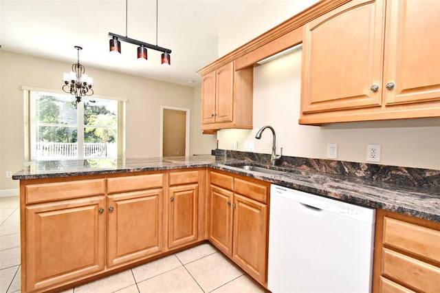 kitchen with white dishwasher, a sink, dark stone countertops, a peninsula, and light tile patterned flooring