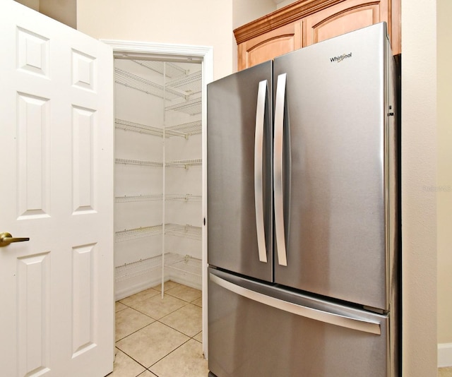 kitchen with freestanding refrigerator and light tile patterned flooring