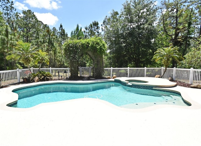 view of pool featuring a pool with connected hot tub, a fenced backyard, and a patio area