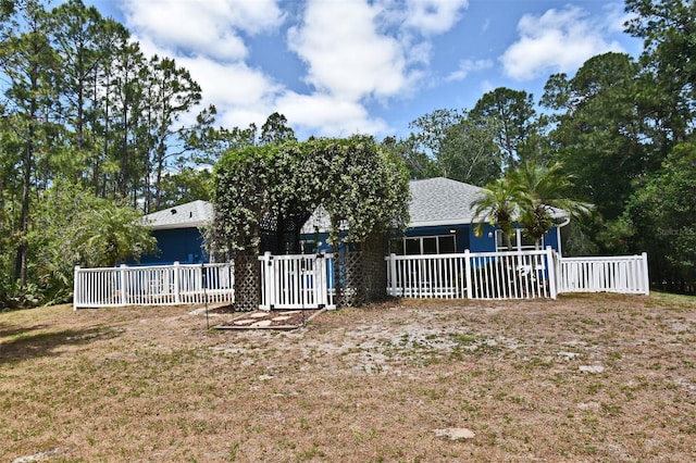 back of house featuring fence and a yard