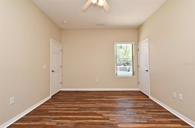unfurnished room featuring baseboards, a ceiling fan, wood finished floors, and visible vents