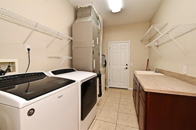 laundry area with a sink, light tile patterned floors, cabinet space, and washer and clothes dryer