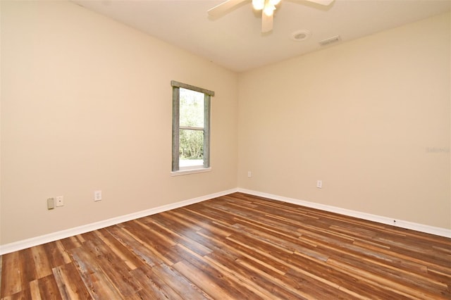 unfurnished room with visible vents, a ceiling fan, dark wood-style flooring, and baseboards