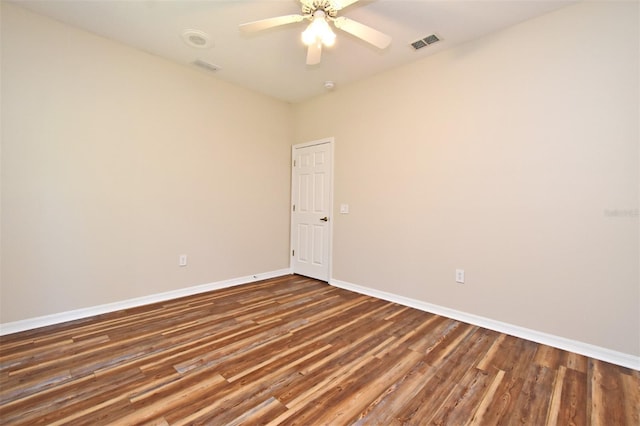 unfurnished room with ceiling fan, baseboards, visible vents, and wood finished floors