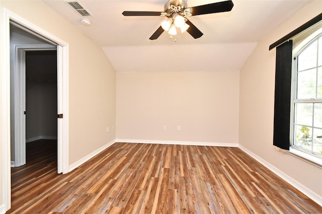 interior space featuring a ceiling fan, vaulted ceiling, wood finished floors, and visible vents
