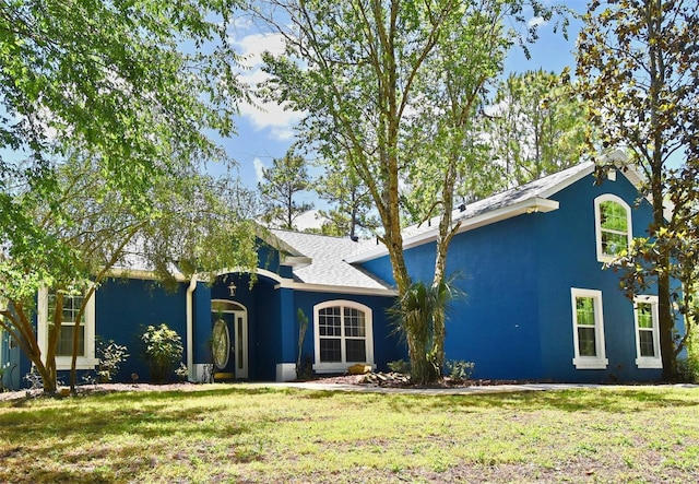 view of front facade featuring a front yard and stucco siding