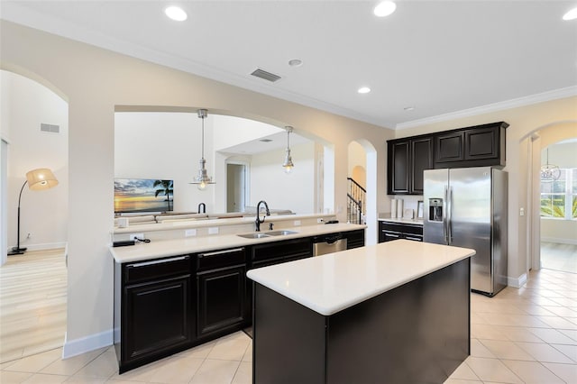 15485 Sandfield Loop, Winter Garden, FL 34787 - kitchen featuring appliances with stainless steel finishes, a sink, arched walkways, light countertops, and crown molding