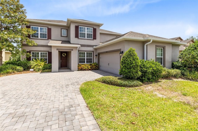 15485 Sandfield Loop, Winter Garden, FL 34787 - view of front facade featuring stucco siding, an attached garage, decorative driveway, and a front lawn