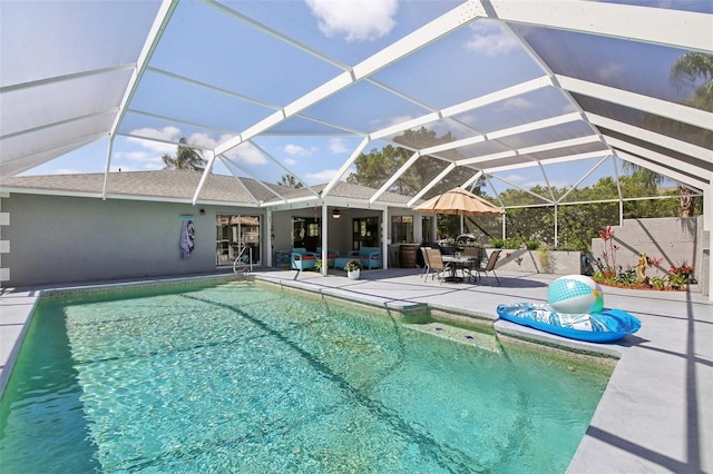 pool featuring a patio, ceiling fan, and glass enclosure